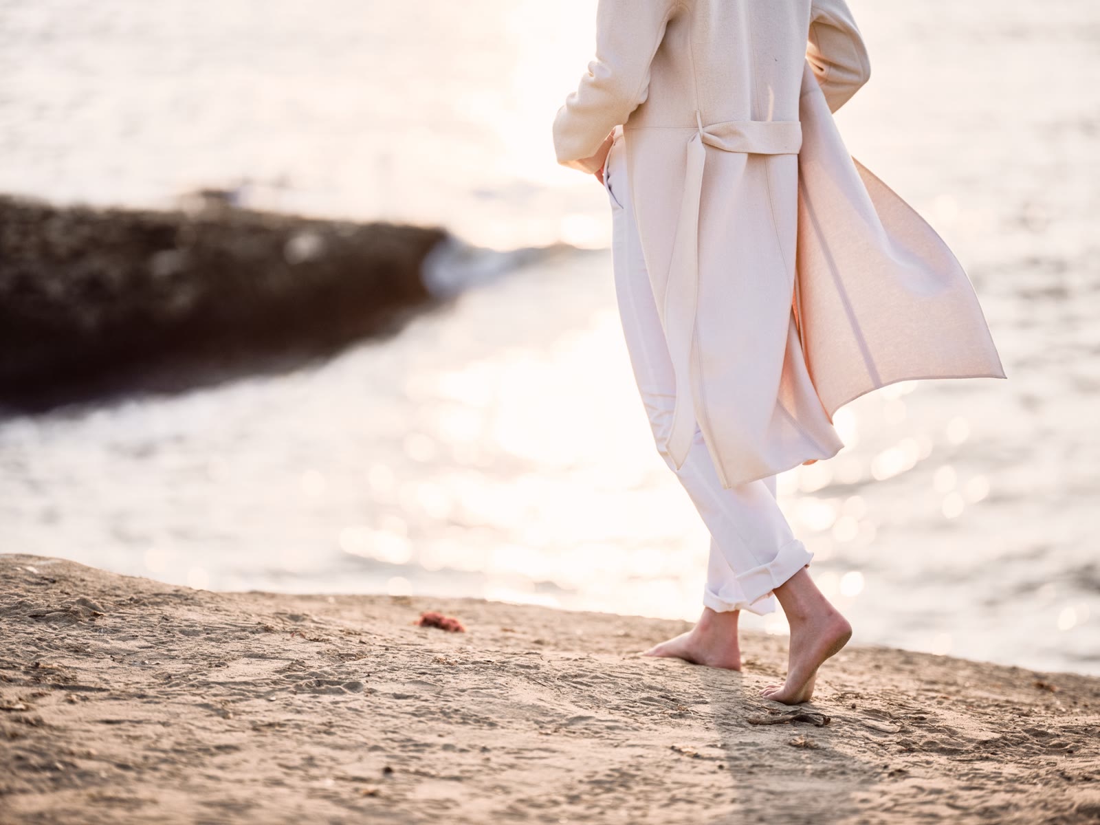 Walking barefoot along the shore at sunset