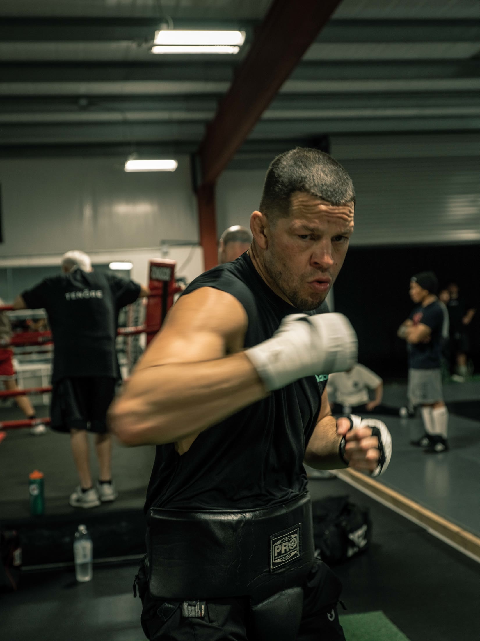 Nate Diaz shadowboxing toward the camera with taped fists