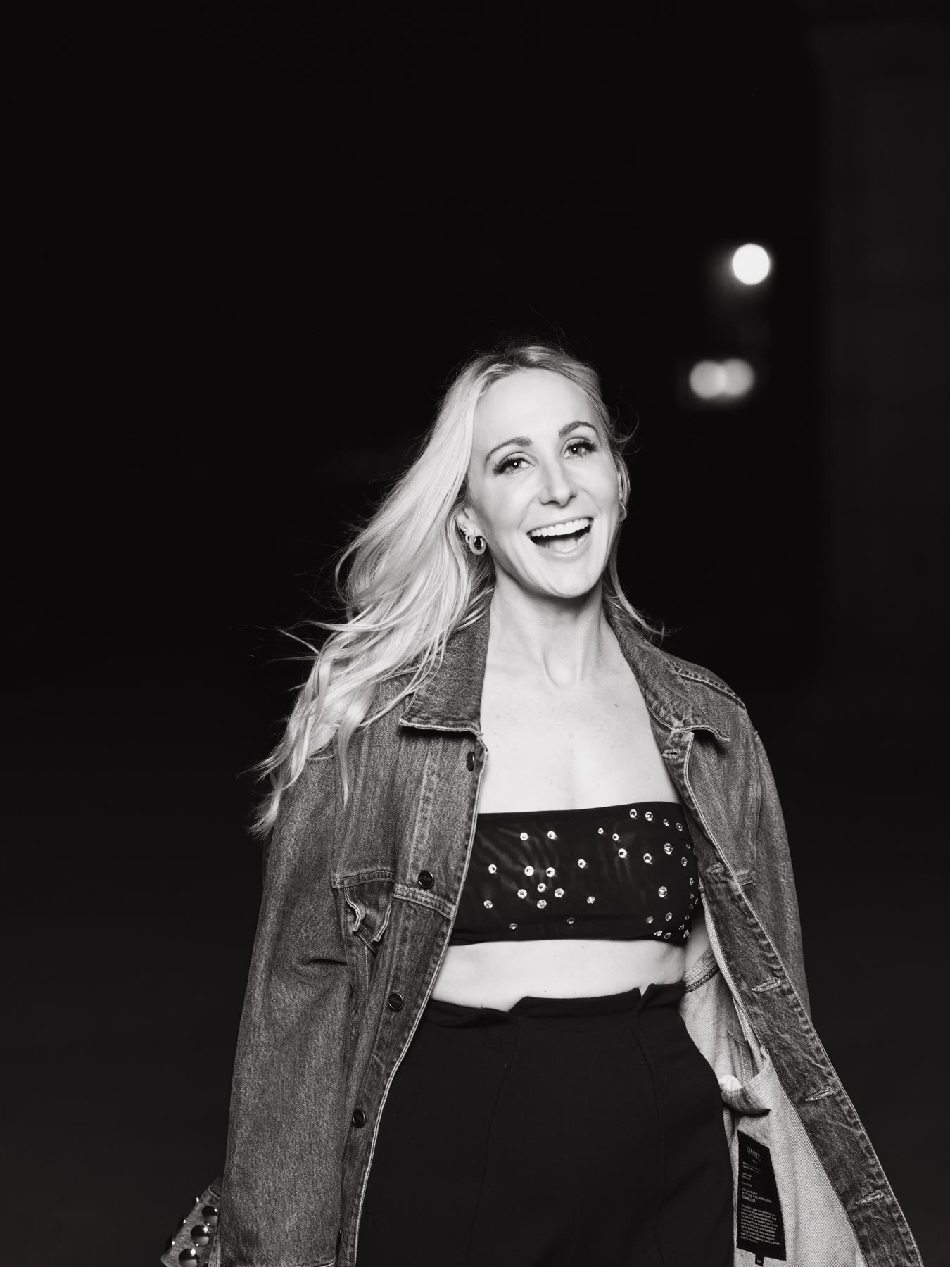 Black-and-white portrait of Nikki Glaser laughing mid-shoot