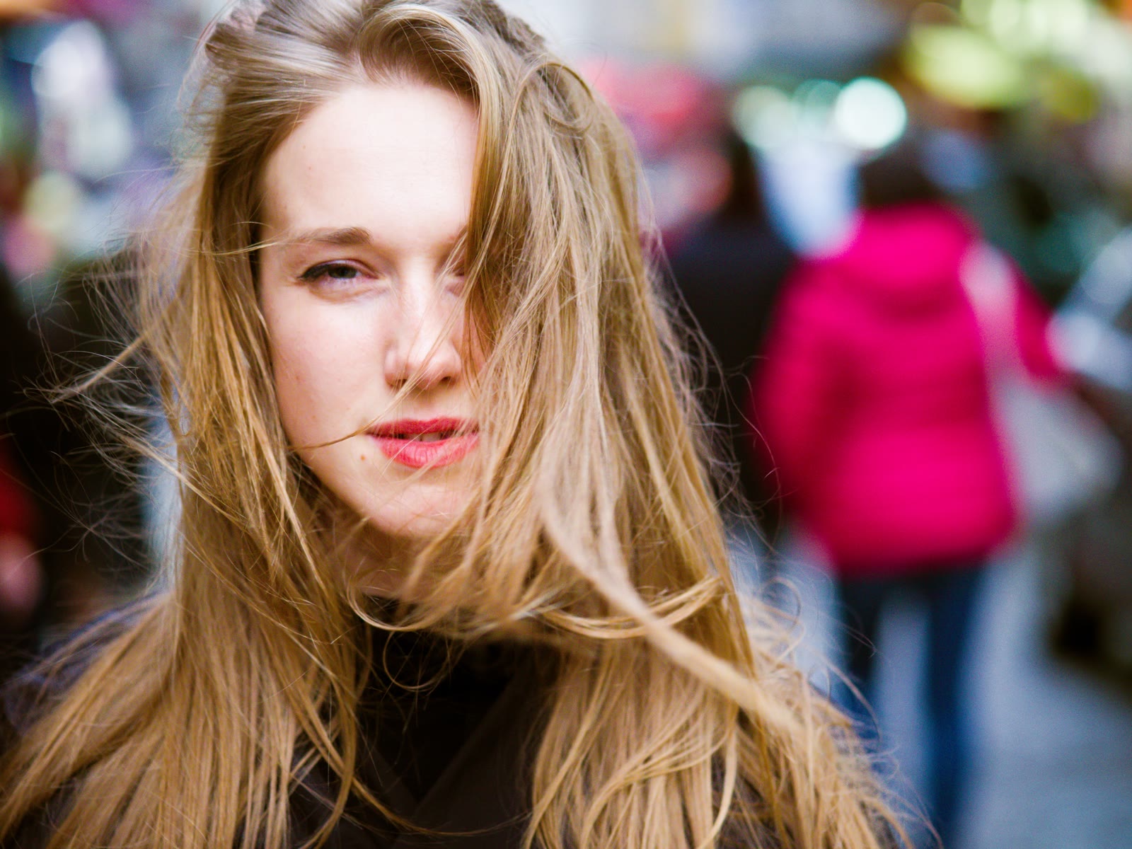 Editorial portrait on a busy Paris street, hair caught in the wind